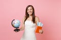 Happy bride woman in white wedding dress holding world globe, passport boarding pass ticket, going abroad for honeymoon Royalty Free Stock Photo