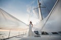 Happy bride on a yacht. White yacht with sail set goes along the island.