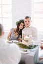 Happy bridesmaid and groomman smiling and hugging at the wedding table. Group of people sitting at wedding table in the