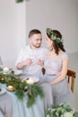 Happy bridesmaid and groomman smiling and hugging at the wedding table. Group of people sitting at wedding table in the