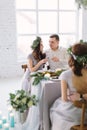 Happy bridesmaid and groomman at the wedding table drink champagne. Group of people sitting at wedding table in the