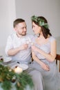 Happy bridesmaid in pine wreath and groomman at the wedding table drink champagne. Group of people sitting at wedding