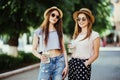 Happy positive moments of two stylish girls hugging with cocktails on street in city. Closeup portrait funny joyful attarctive you Royalty Free Stock Photo
