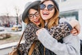 Happy brightful positive moments of two stylish girls hugging on street in city. Closeup portrait funny joyful Royalty Free Stock Photo