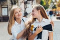 Happy brightful positive moments of two stylish girls hugging on street in city. Closeup portrait funny joyful attarctive young Royalty Free Stock Photo