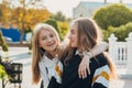 Happy brightful positive moments of two stylish girls hugging on street in city. Closeup portrait funny joyful attarctive young Royalty Free Stock Photo