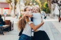 Happy brightful positive moments of two stylish girls hugging on street in city. Closeup portrait funny joyful attarctive young Royalty Free Stock Photo