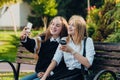 Close up lifestyle selfie portrait of two young positive woman having fun and making selfie, teenage hipster trendy clothes, long Royalty Free Stock Photo
