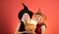 Happy brightful positive moments of two stylish girlson orange background. Surprise. Halloween girls through hole in