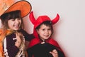 Happy brother and sister at Halloween party. People are having fun indoors. Children in costumes of skeletons and witches. Royalty Free Stock Photo