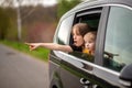 Happy brother and sister looking out car window