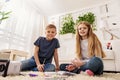 Happy brother and sister playing in living room Royalty Free Stock Photo