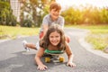 Happy brother and sister playing with longboard outdoor - Young people having fun in summer time outside - Youth, love, family and Royalty Free Stock Photo