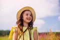 A happy brunette cute girl, in a straw hat , stands in nature in the summer, against the background of a blue sky Royalty Free Stock Photo