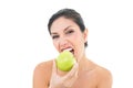 Happy brunette eating a green apple and looking at camera Royalty Free Stock Photo