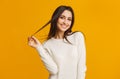 Happy brunette girl flirting and touching her long beautiful hair Royalty Free Stock Photo