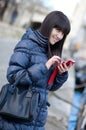 Happy brunette girl sending an sms to some Royalty Free Stock Photo