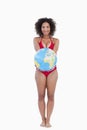 Happy brunette holding a globe beach ball Royalty Free Stock Photo