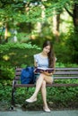 Young woman with a notebook in hands sitting on a park bench Royalty Free Stock Photo