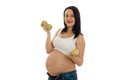 Happy brunette pregnant woman posing with green apple in her hands and smiling on camera isolated on white background Royalty Free Stock Photo
