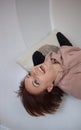Happy brunette woman with short hair is lying upside down laughing joyfully Royalty Free Stock Photo