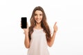 Happy brunette woman in t-shirt showing blank smartphone screen Royalty Free Stock Photo