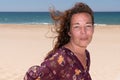 Happy brunette woman walking on beach wind on hairs Royalty Free Stock Photo
