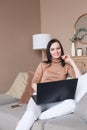 Happy brunette woman working on a laptop at home Royalty Free Stock Photo