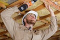 Happy builder drilling wood ceiling