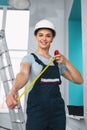 Happy builder holding a measuring tape