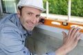 happy builder posing with spirit level at construction site Royalty Free Stock Photo