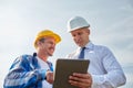 Happy builders in hardhats with tablet pc outdoors Royalty Free Stock Photo