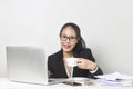 Asian woman working with laptop at white working table, diligent professional working woman drinking coffee while working on lapto Royalty Free Stock Photo