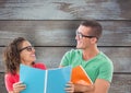 Happy business colleagues holding files against wooden wall