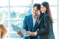 Happy business couple standing together  checking work on laptop. Royalty Free Stock Photo