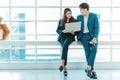 Happy business couple standing together  checking work on laptop near the window. Royalty Free Stock Photo