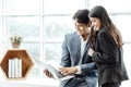 Happy business couple standing together  checking work on laptop. Royalty Free Stock Photo