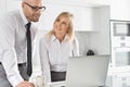 Happy business couple working on laptop in kitchen Royalty Free Stock Photo