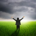 Happy business man in green rice field and rainclouds