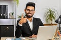 Happy business man looking approvingly at camera showing thumbs up, like positive sign, good news