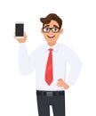 Happy business man showing a new brand, latest smartphone. Young man holding blank screen cell or mobile phone in hand. Royalty Free Stock Photo