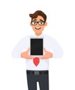 Happy business man showing a new tablet. Trendy young person holding latest digital tab. Male character design illustration. Royalty Free Stock Photo