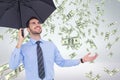 Happy business man under umbrella looking at money rain against white background