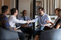 Happy business partners shaking hands at group negotiations in office Royalty Free Stock Photo