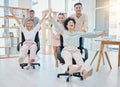 Happy business people doing office games with chair at work, celebration of success and freedom at startup company and Royalty Free Stock Photo