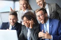 Happy business people laugh near laptop in the office. Successful team coworkers joke and have fun together at work. Royalty Free Stock Photo