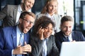 Happy business people laugh near laptop in the office. Successful team coworkers joke and have fun together at work. Royalty Free Stock Photo