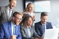 Happy business people laugh near laptop in the office. Successful team coworkers joke and have fun together at work. Royalty Free Stock Photo