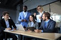 Happy business people laugh near laptop in the office. Successful team coworkers joke and have fun together at work. Royalty Free Stock Photo