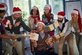 Happy business people in santa hat with Christmas present at company party celebrating holiday Royalty Free Stock Photo